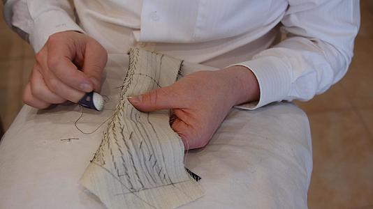 英俊的裁缝女裁缝手垫缝合衣领垫针固定两层或两层以上的织物视频的预览图
