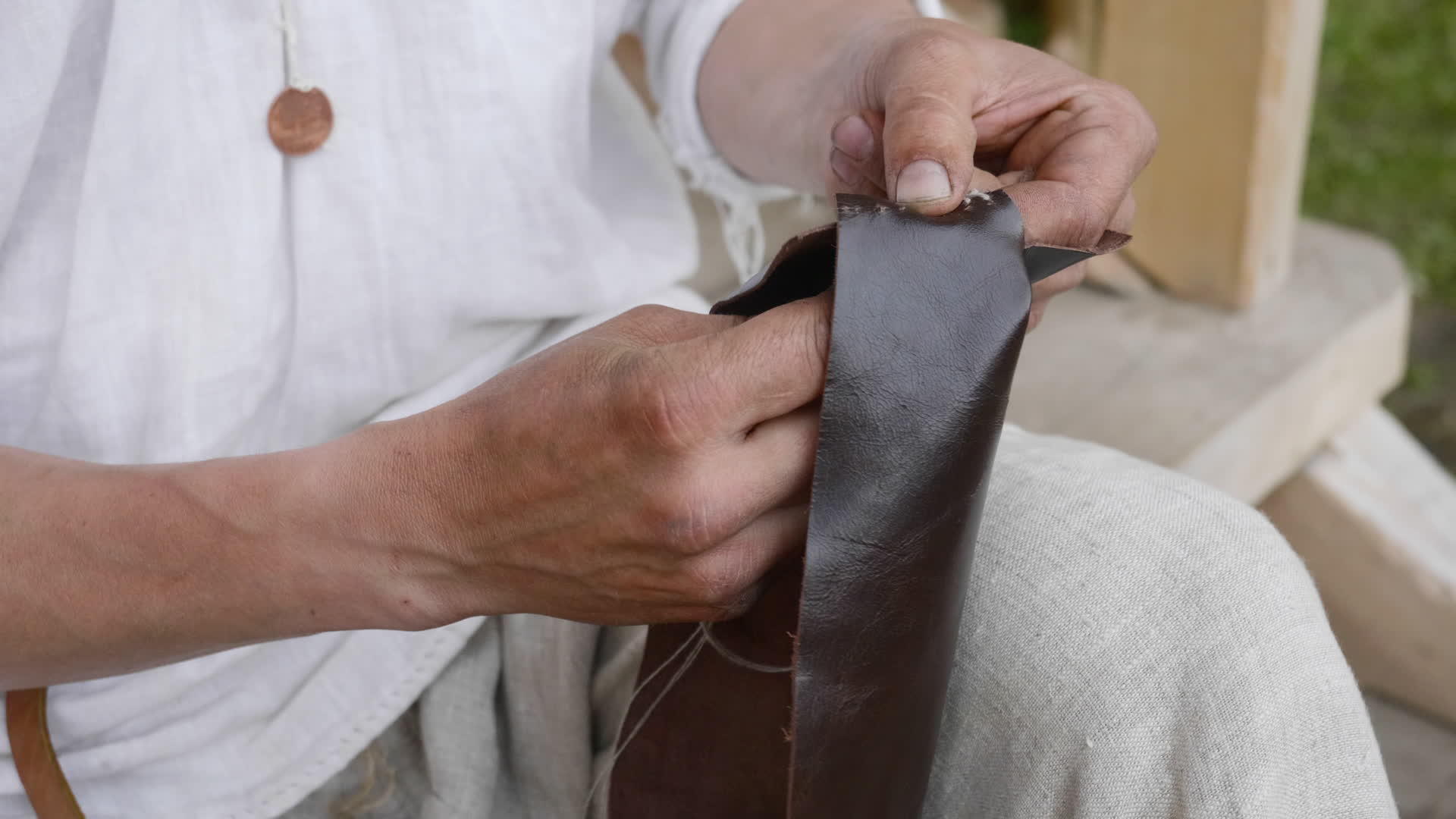 关闭男性手工缝针皮工匠缝制皮衣加工制造皮革制品视频的预览图