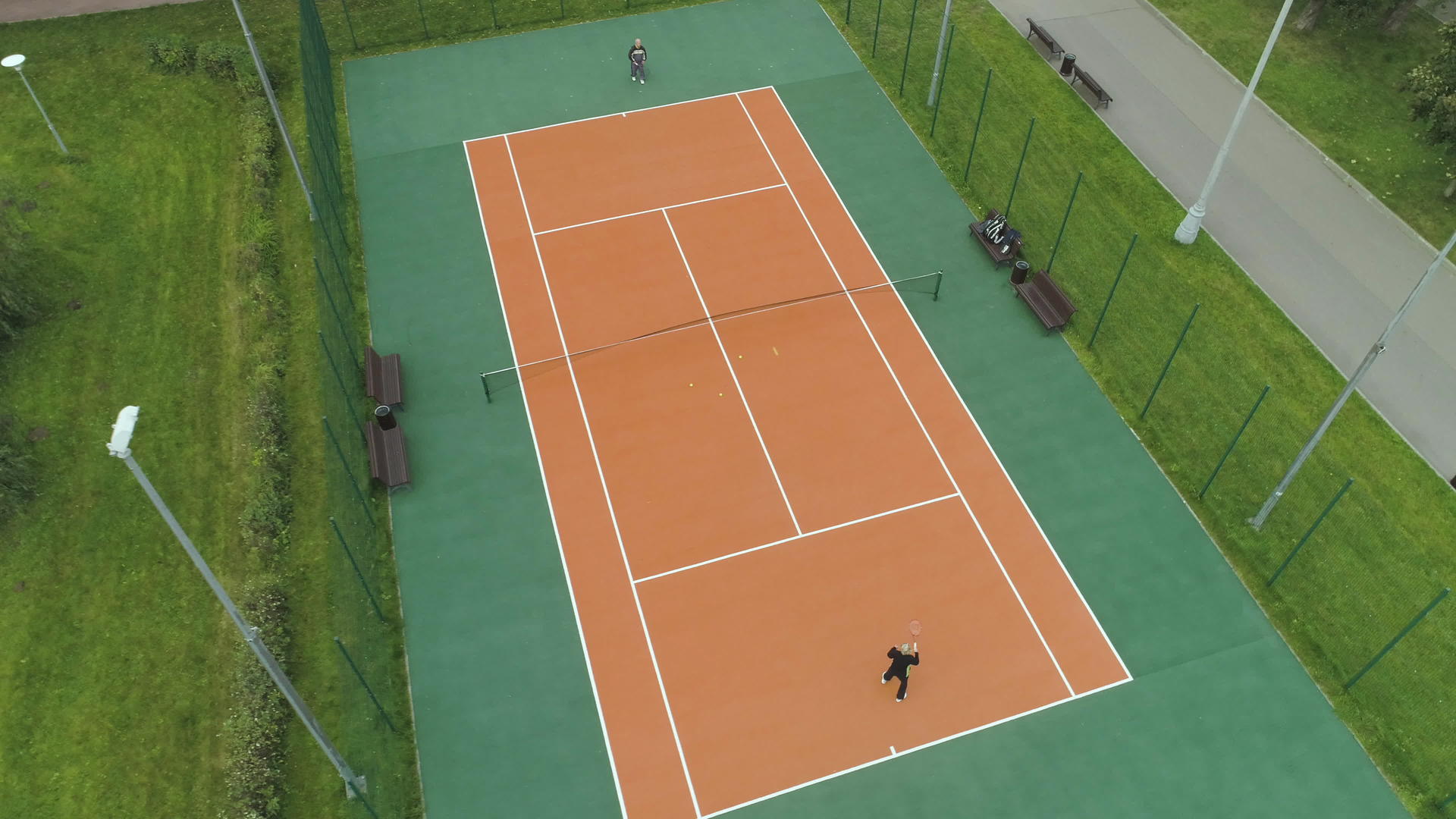 球员们在绿色公园的球场上打网球无人机到处飞来飞去视频的预览图
