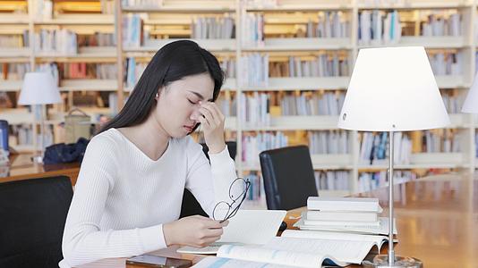 图书馆学习疲惫的女大学生视频的预览图