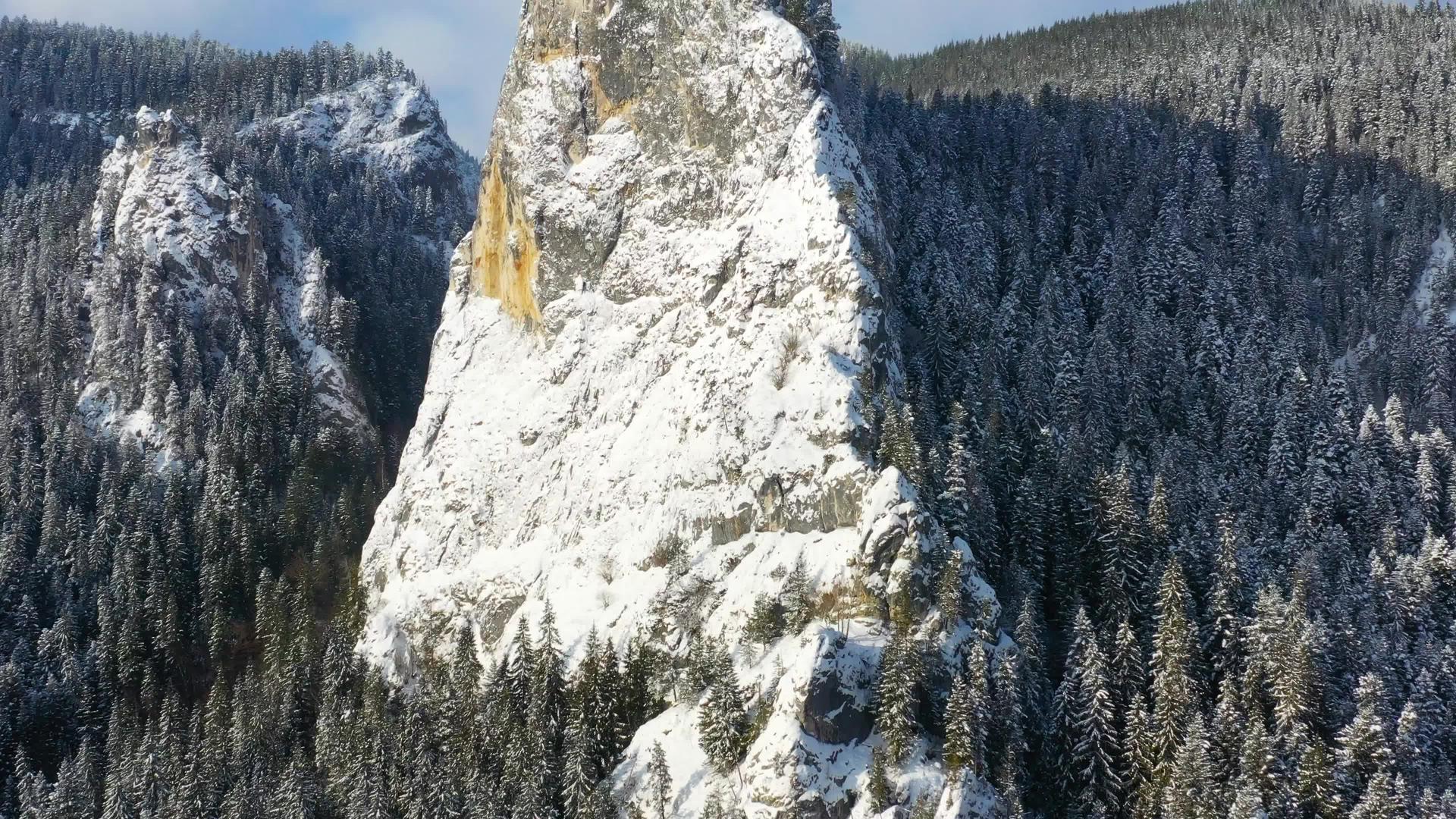 冬季巨石附近的移动无人飞机山区的冬季场景视频的预览图