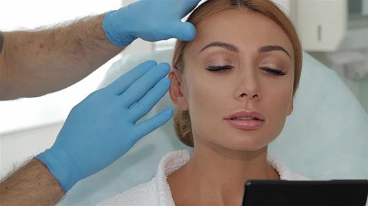 美容师把皮肤伸向顾客的眉毛视频的预览图