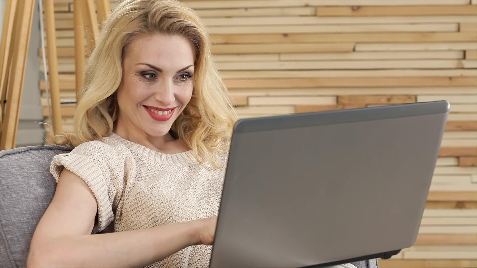 一个迷人的女孩膝盖上有一台笔记本电脑视频的预览图