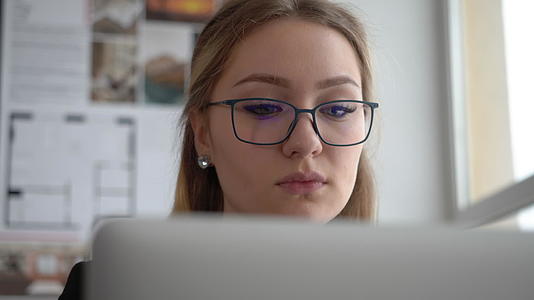 戴眼镜的漂亮女工程师在创意办公室用笔记本电脑工作视频的预览图