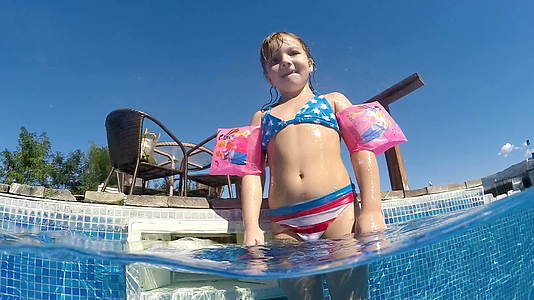 这个可爱的女孩在温泉中心的游泳池里微笑到相机的水下风景视频的预览图