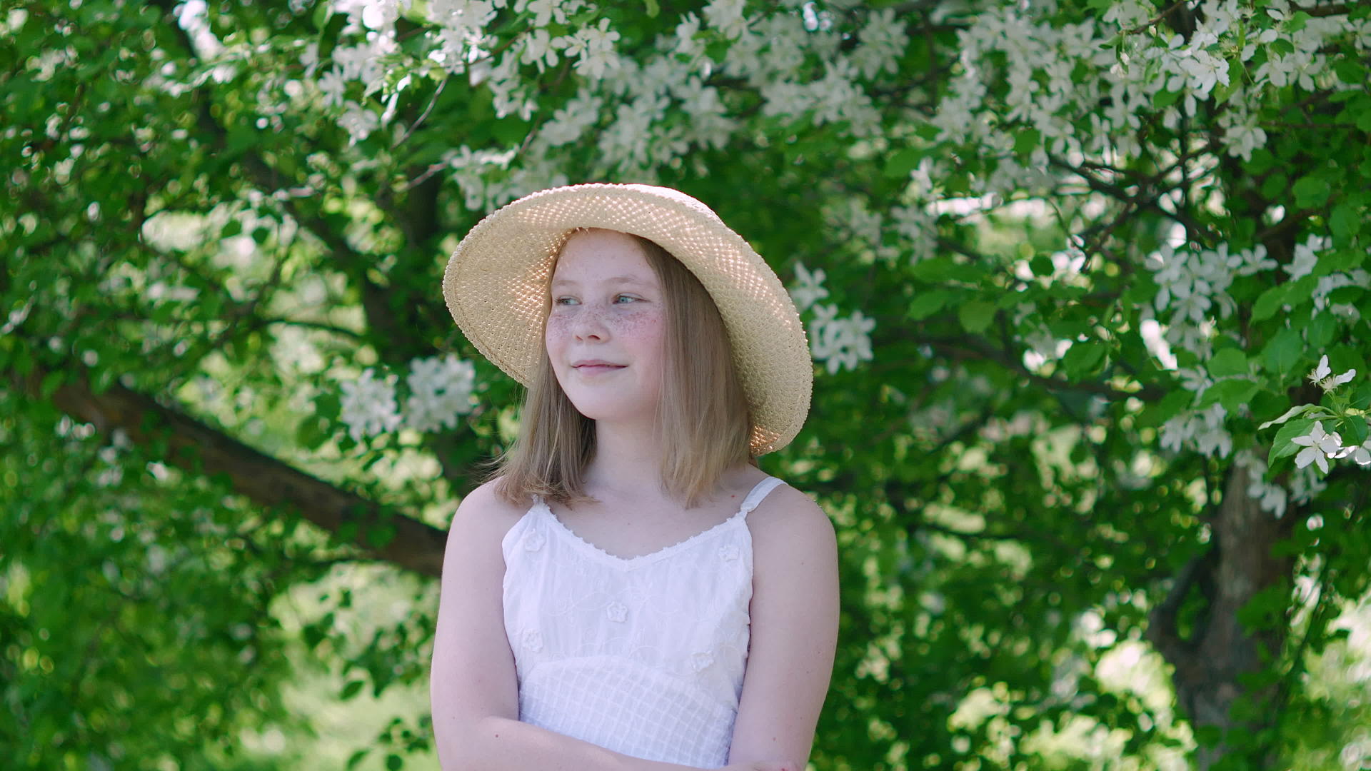 微笑的年轻女孩看着开阔的花园视频的预览图