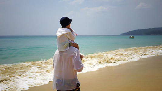 父亲和儿子在海滩上徒步旅行视频的预览图
