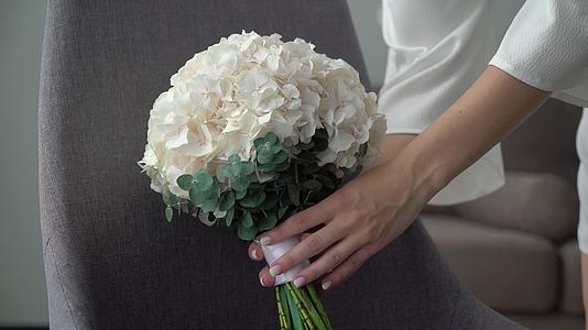 白色绣球花花束新娘婚礼花束新婚夫妇早上准备卧室视频的预览图