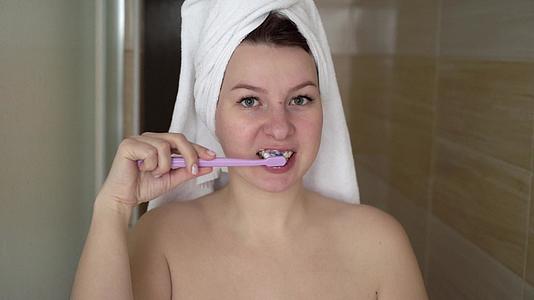 在现代洗手间刷牙的女人视频的预览图