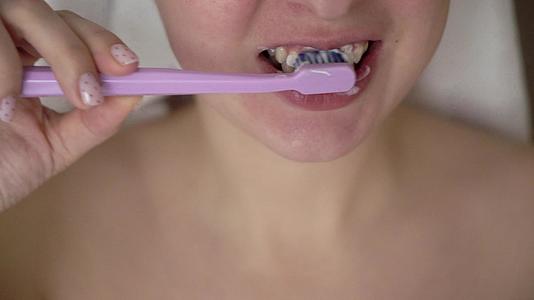 在现代洗手间刷牙的女人视频的预览图