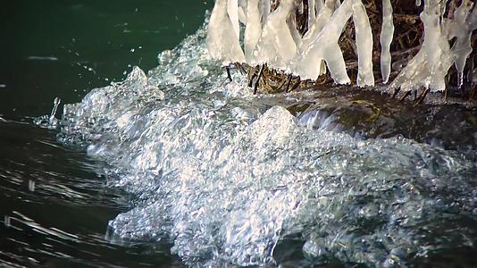 冰冻的雪和冰冷的石头在水中有石头和雪的溪流视频的预览图