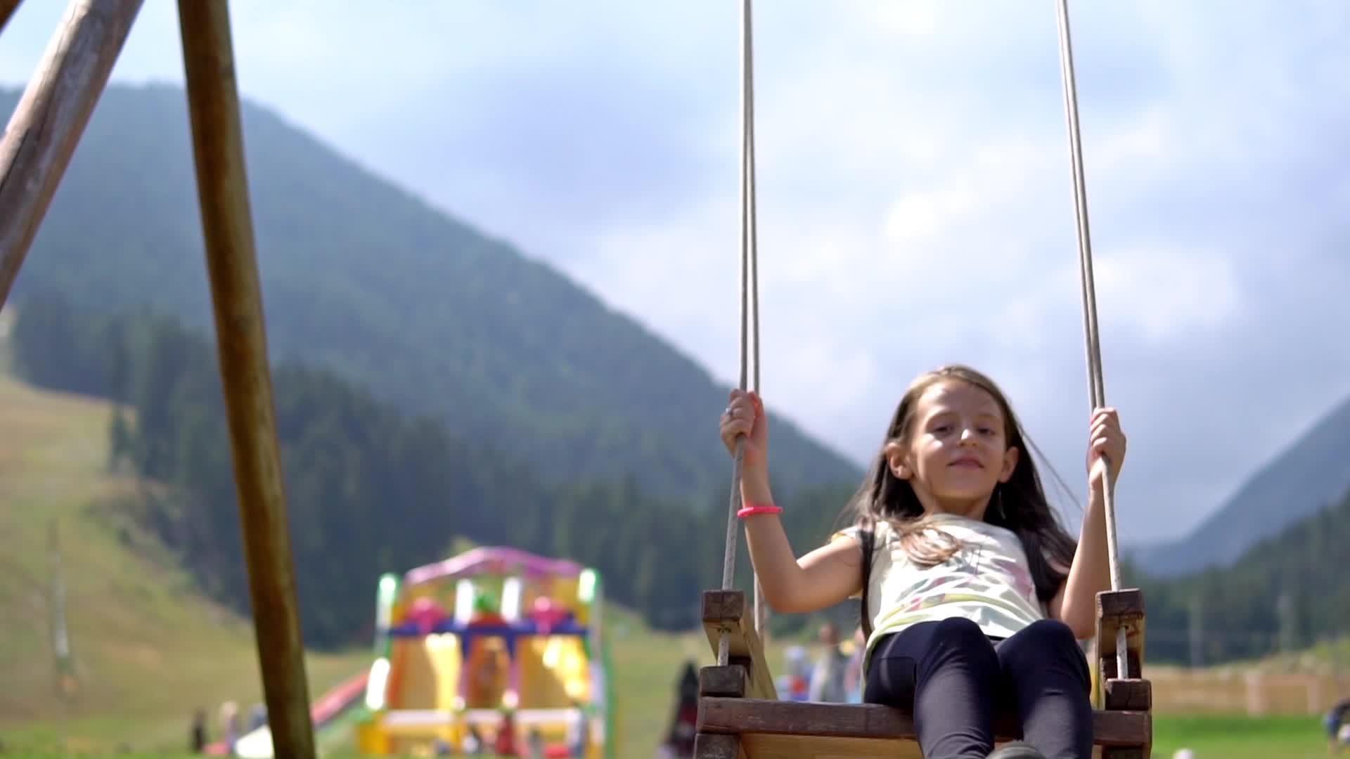 女孩在山上的操场上摇摆慢慢地移动电影Dof视频的预览图