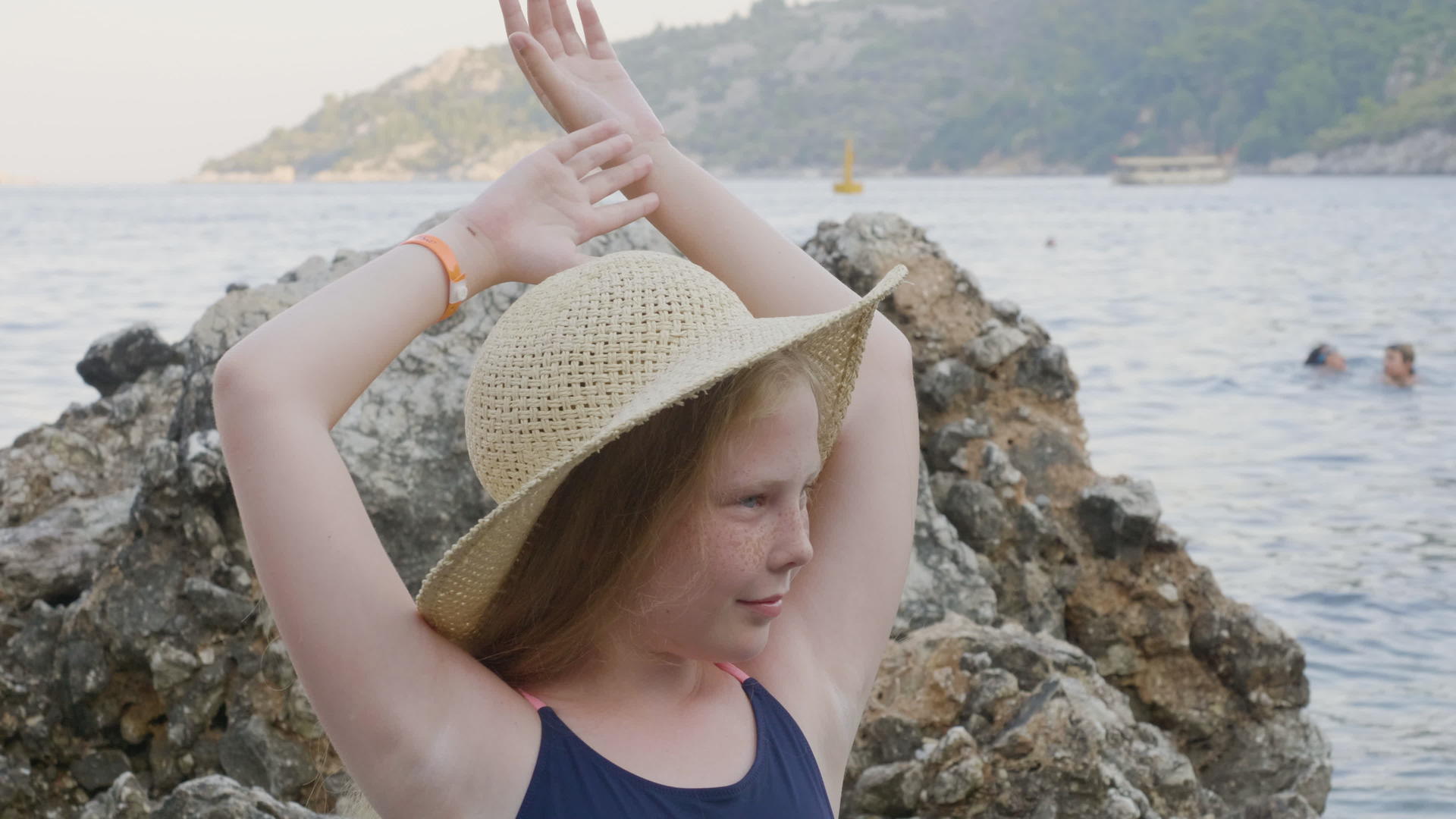 穿着漂亮帽子的漂亮女孩在海滩上摆姿势视频的预览图