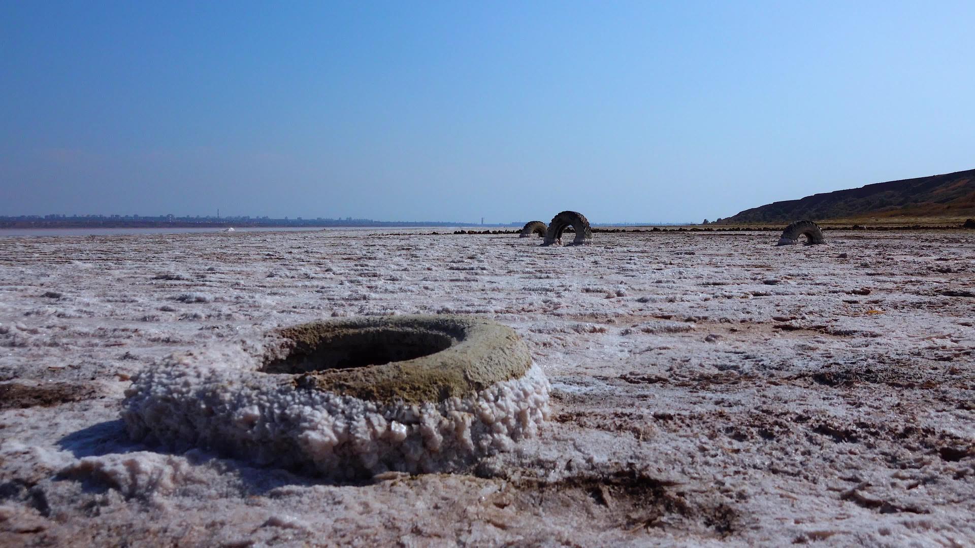 盐湖盐晶体自沉盐覆盖岩石和旧车轮干燥湖中的高盐度视频的预览图