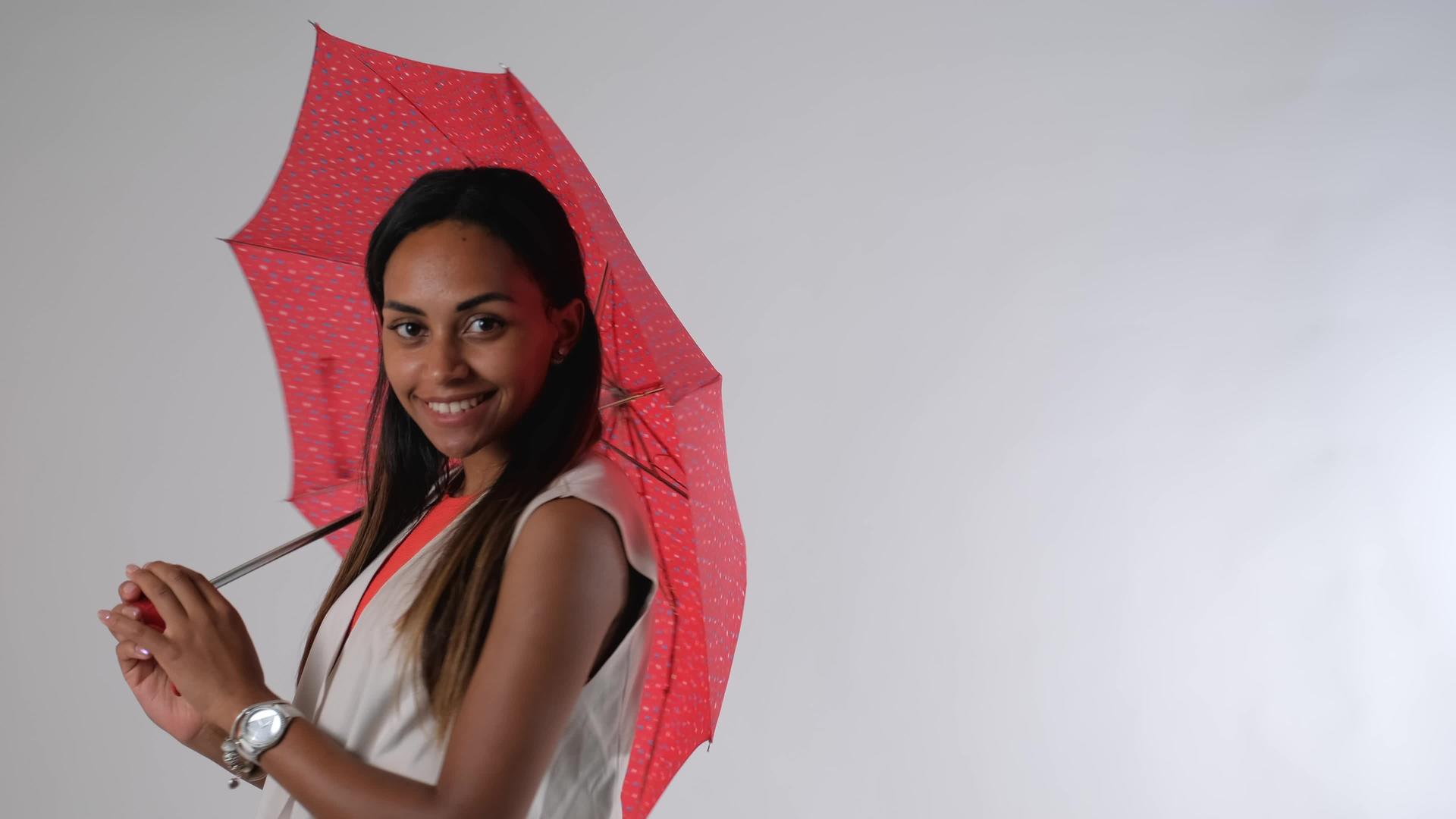 一个有吸引力的非洲模型与雨伞作为时尚杂志摄影照片视频的预览图
