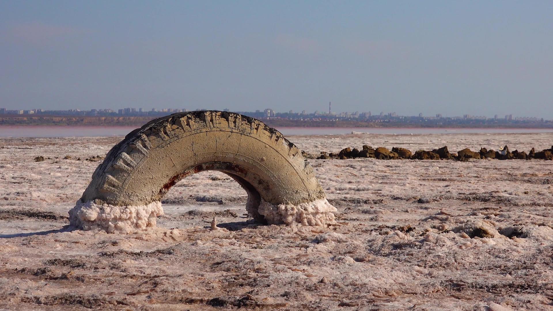 一个垂死的河口湖的底部覆盖着石头和旧轮子视频的预览图