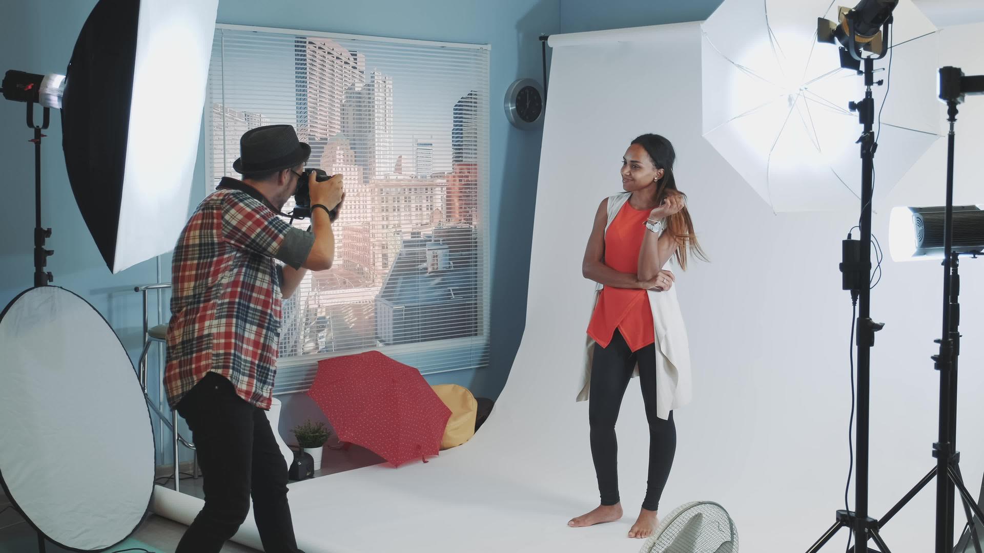 专业摄影师要求模特在工作室拍照时改变姿势视频的预览图