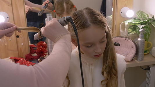 美容师用梳子理发抚摸年轻女孩的美容工作室视频的预览图