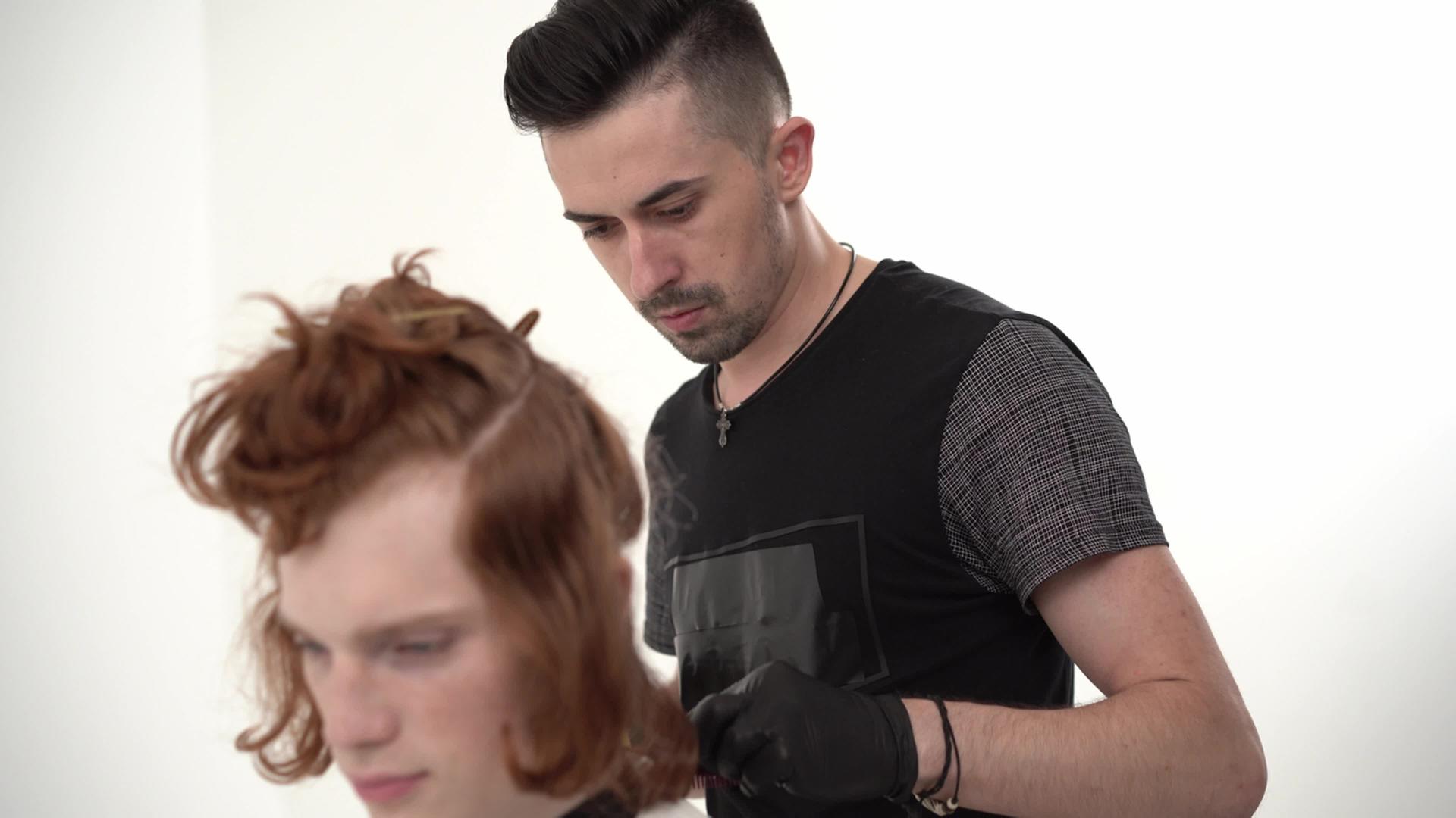 理发师给一个头发红的年轻人理发视频的预览图