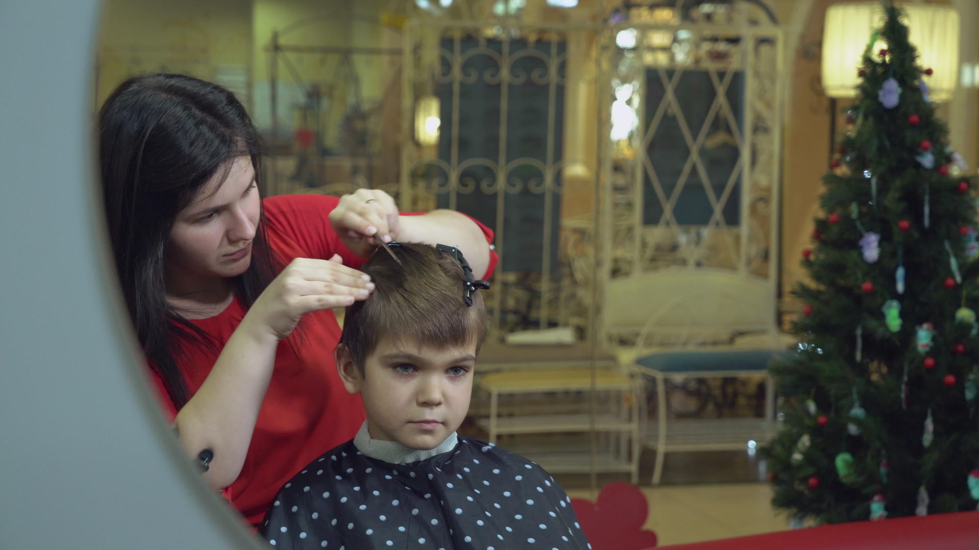 理发店里有一个理发师带着微笑的孩子视频的预览图