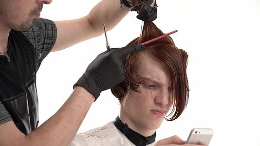 理发师让一个有红发时尚发型的年轻人视频的预览图