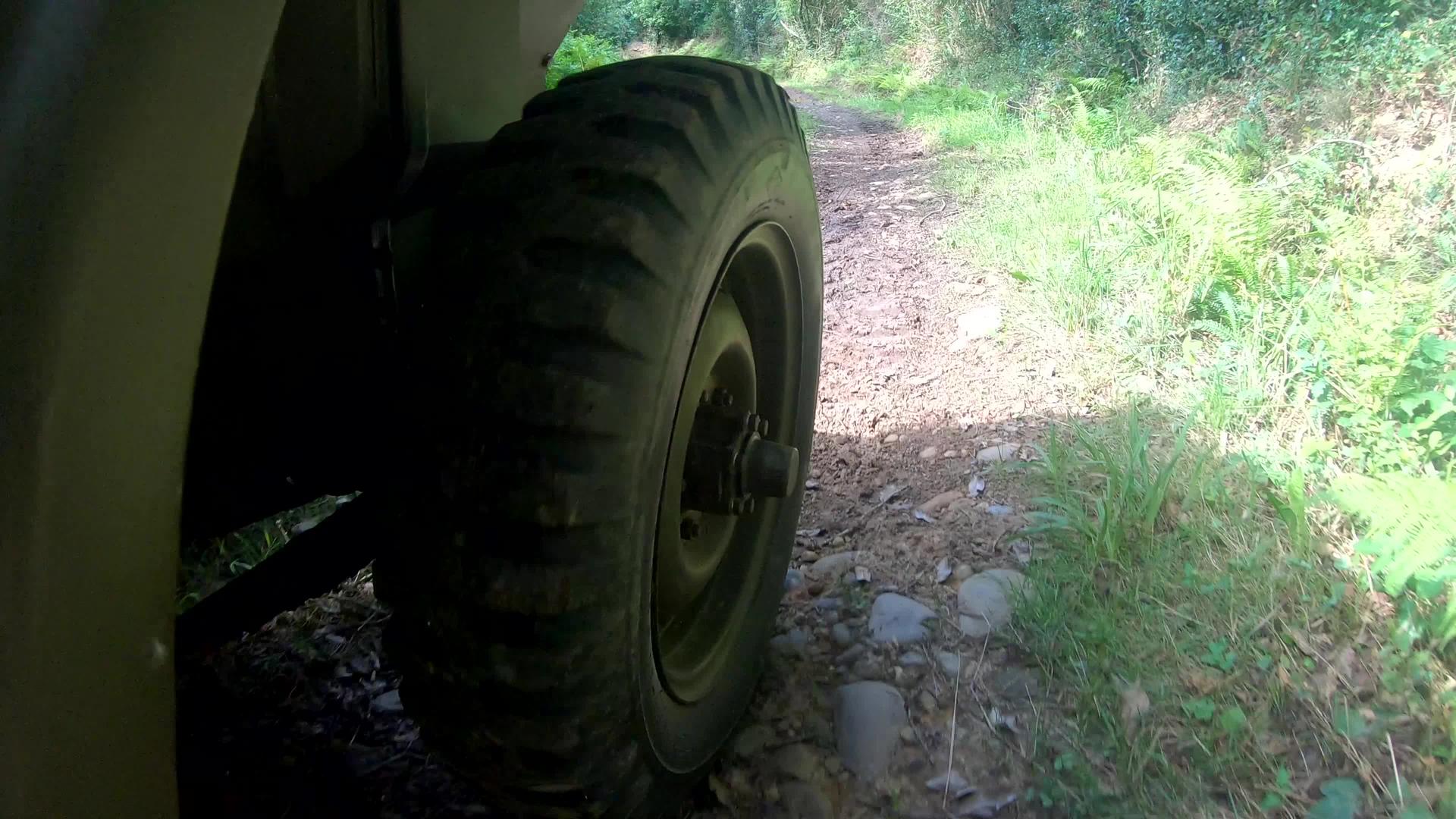土路上军用吉普车的车轮关闭视频的预览图