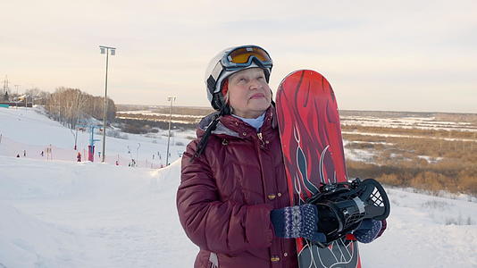 老年妇女站在雪地度假胜地的冬季自然背景滑雪板上视频的预览图