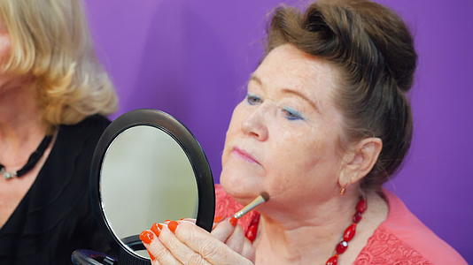 老妇人照镜子用化妆刷化妆视频的预览图