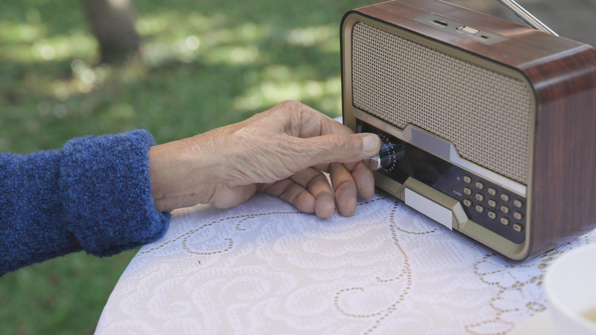 在后院的旧收音机上高级女性用手转动手柄视频的预览图