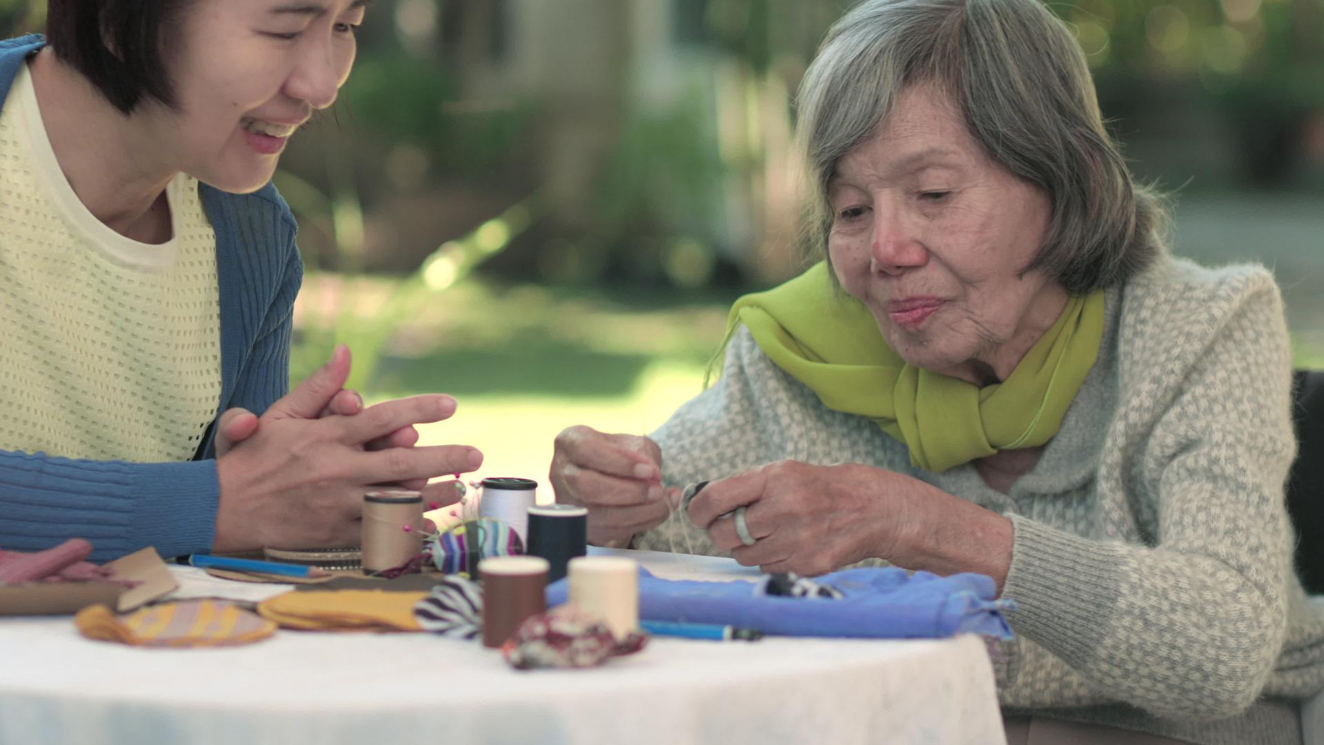 老年妇女和女儿在针头工艺品中接受阿尔茨海默病或痴呆症视频的预览图
