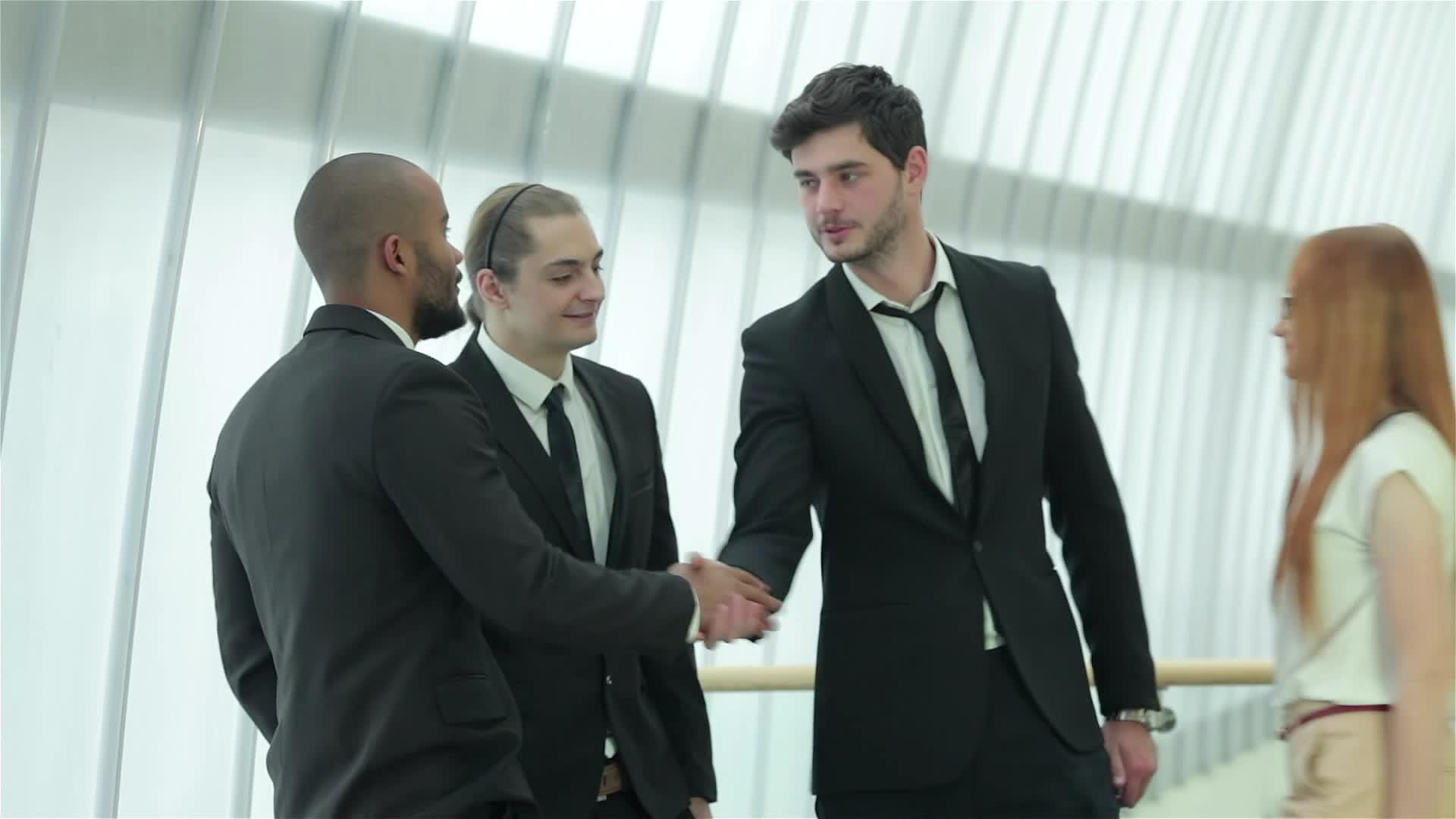 四个成功的商人微笑着握手视频的预览图