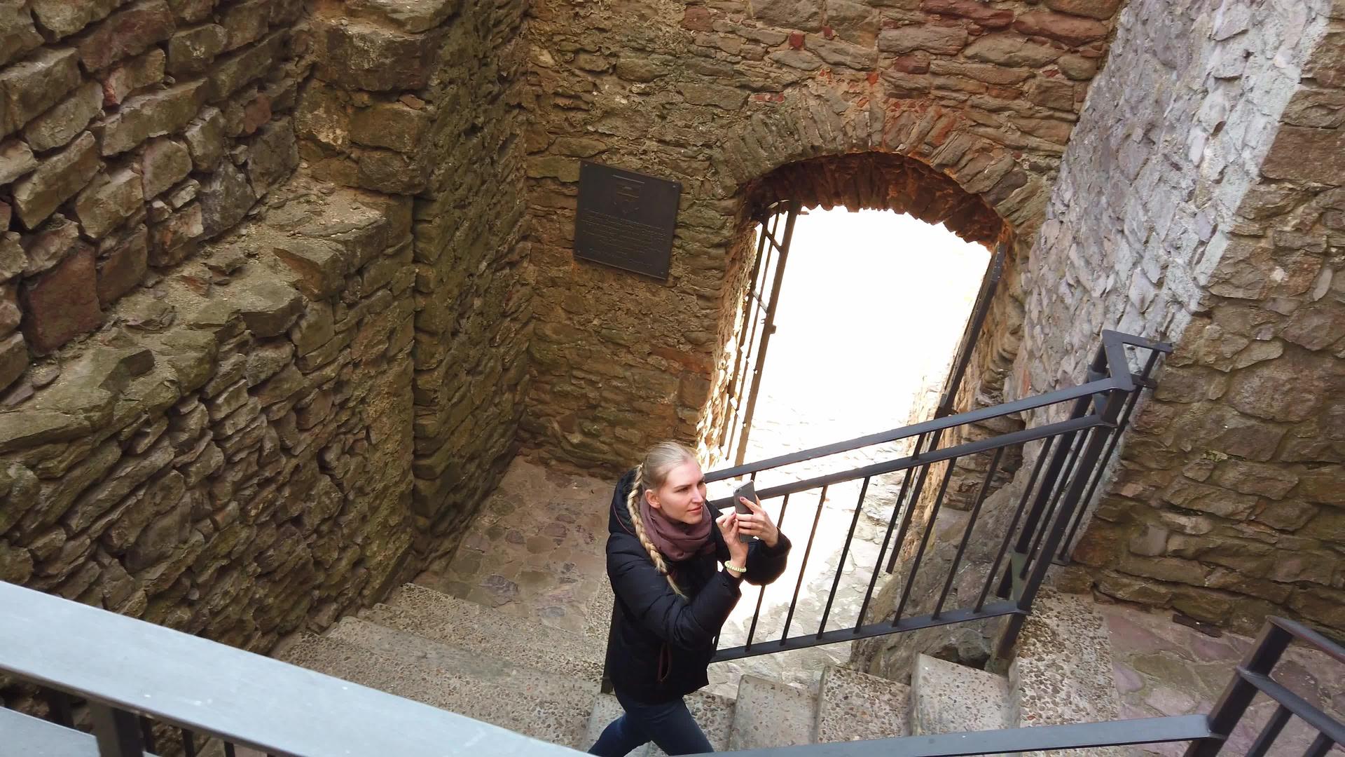 一个女孩走过一座古老的城堡拍视频的预览图