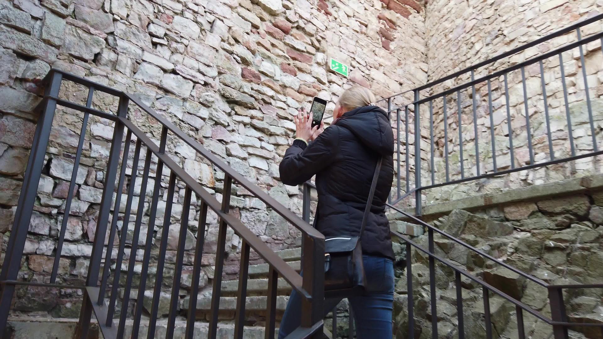 一个女孩走过一座古老的城堡拍视频的预览图