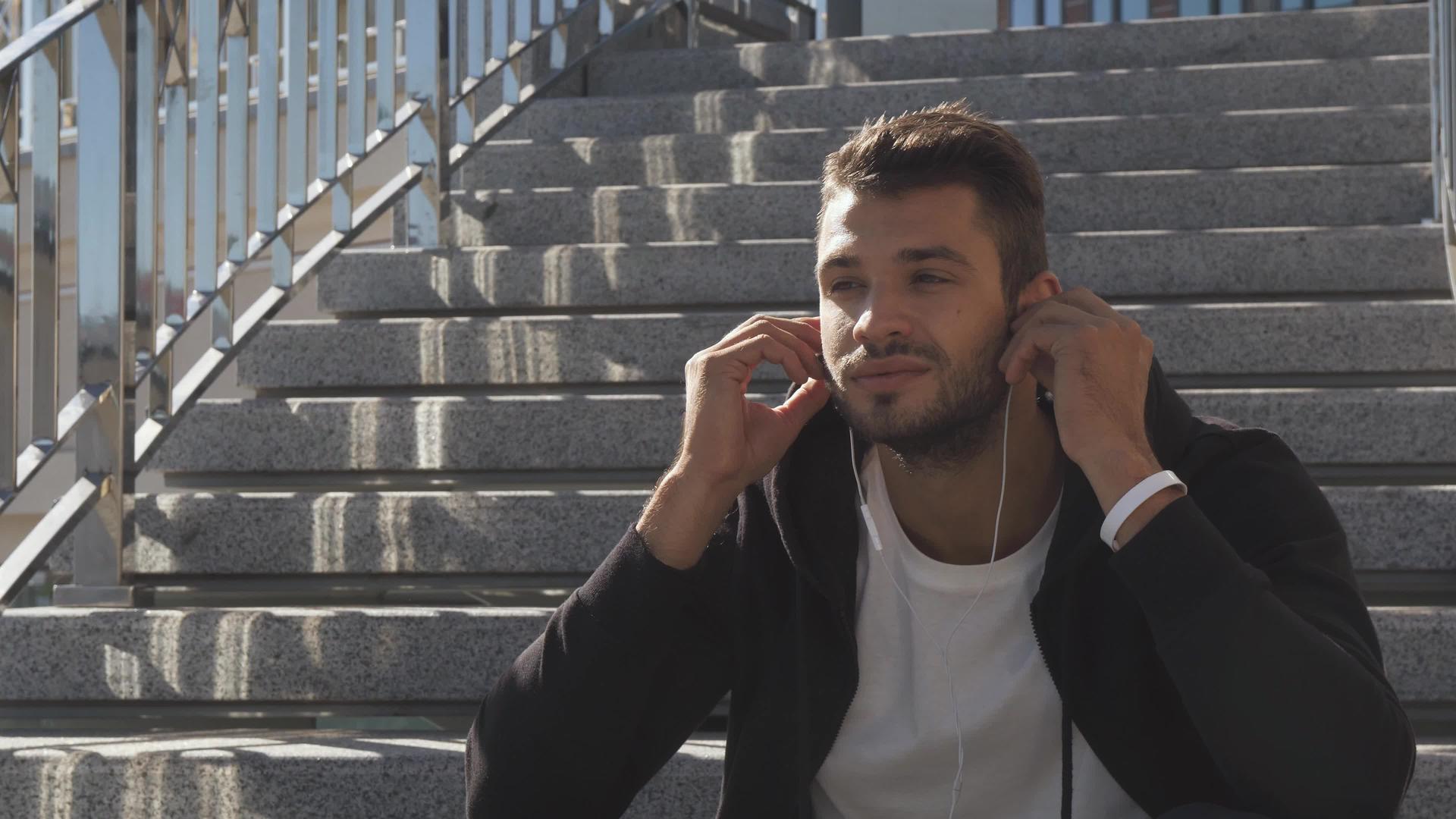 一个年轻人在耳机上听音乐享受清晨的快乐视频的预览图