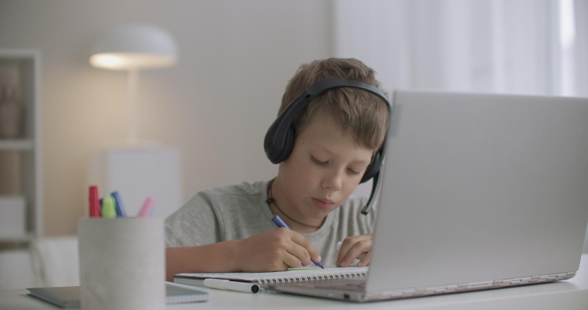 手里戴着耳机和手里拿着笔记本电脑的男孩被孤立了视频的预览图