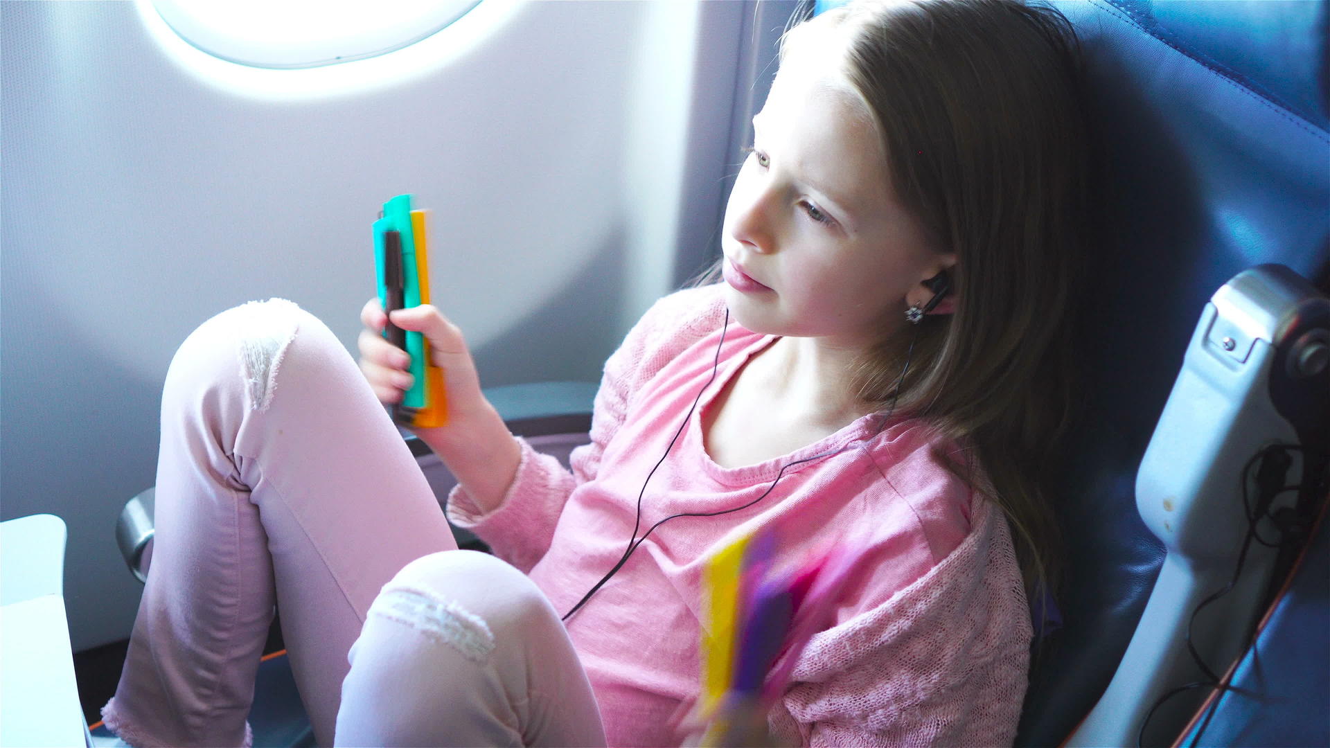 可爱的小女孩乘飞机旅行可爱的孩子膝盖电脑靠近飞机视频的预览图