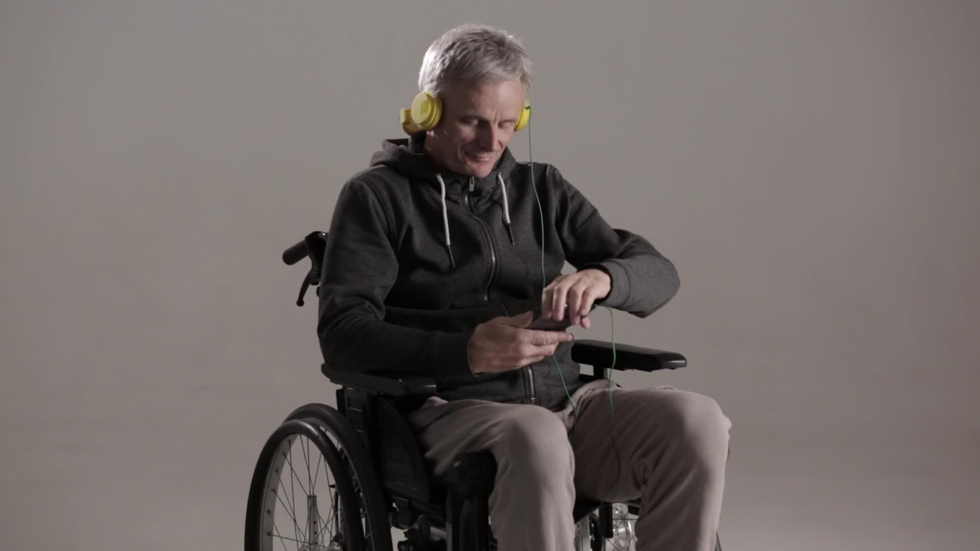 男性残疾人工作室在轮椅上穿着便衣拍摄视频的预览图