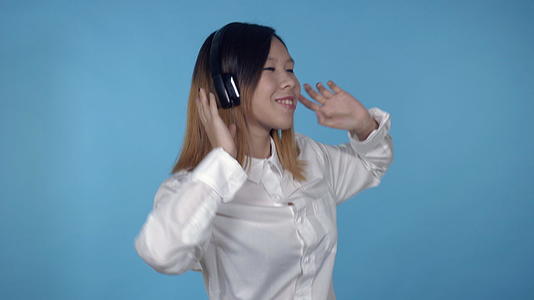 美丽的韩国女性使用耳机视频的预览图