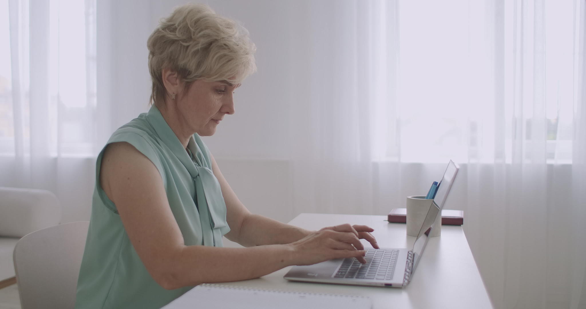 老年妇女在社交网络上使用笔记本电脑键盘聊天视频的预览图