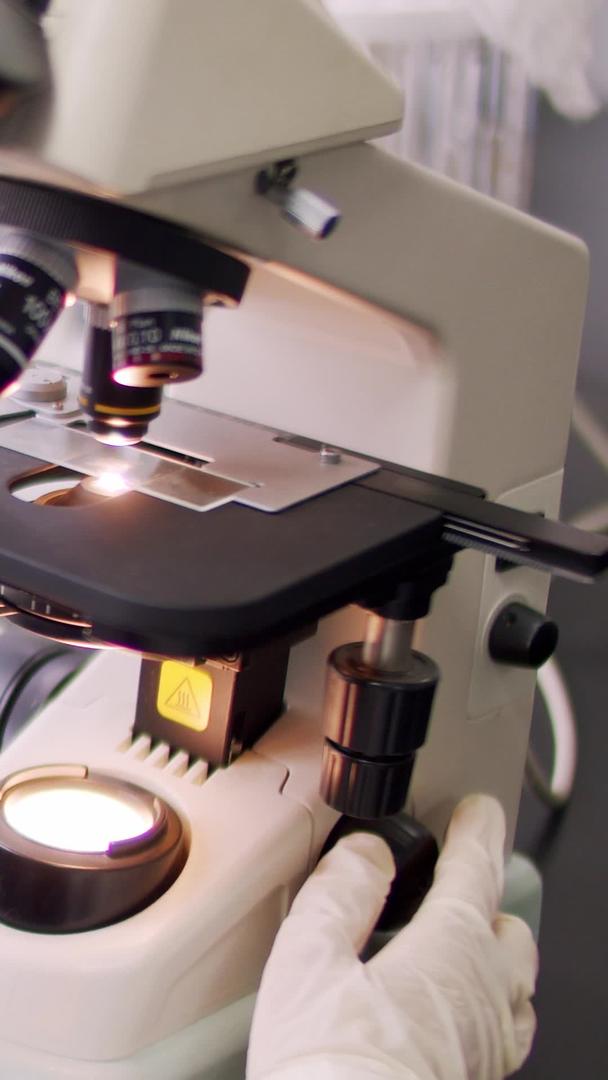 实验室科研人员认真操作显微镜视频的预览图