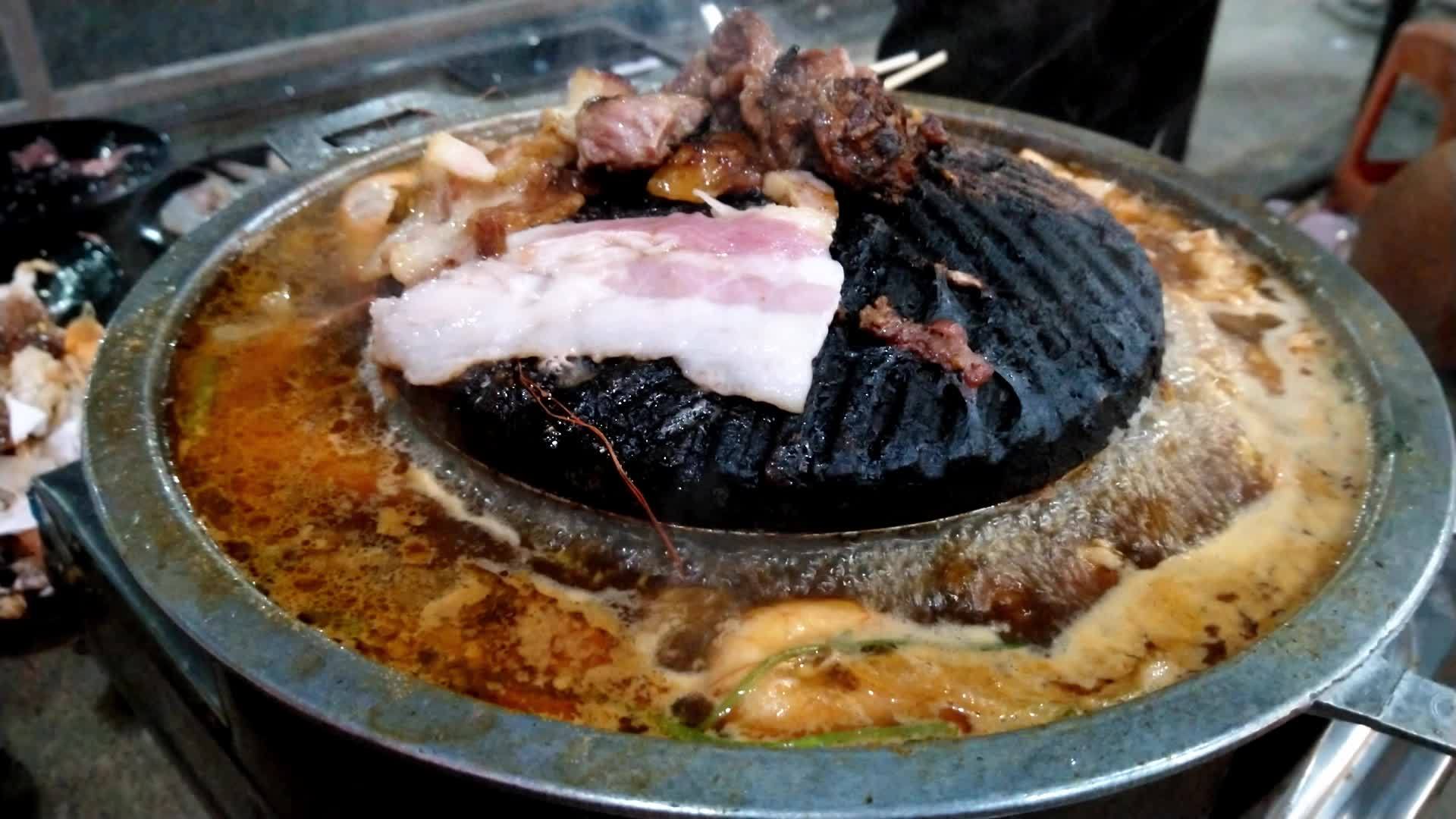 烤猪肉在锅里烧热和虾一起煮汤大量的烟雾视频的预览图