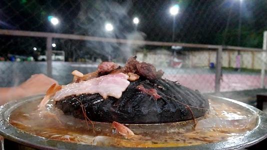 烤猪肉在锅里烧热和虾一起煮汤大量的烟雾视频的预览图