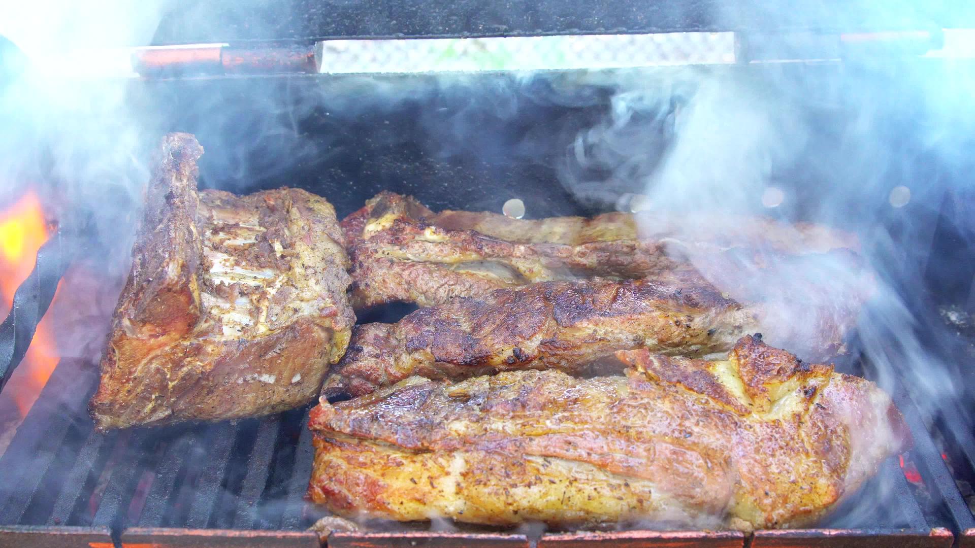 烤排骨熏肉包在木炭烤架上烤红烧和轻烟视频的预览图