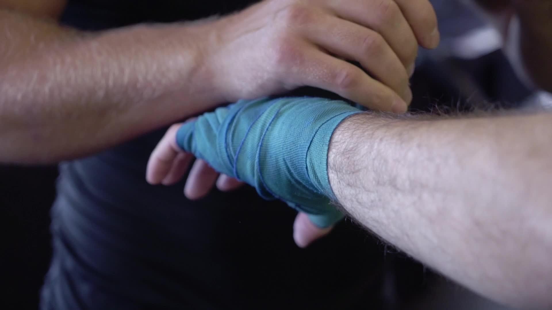 男战斗前男子用手腕系上蓝带在拳击前佩戴和准备视频的预览图