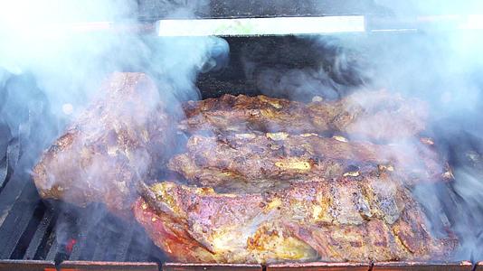 烟熏烤架上的猪肉烧烤排骨在野餐外的烤架上用木炭烘烤视频的预览图