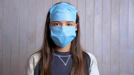 一位美丽的黑发女学生的肖像额头戴着防护性医疗面具视频的预览图