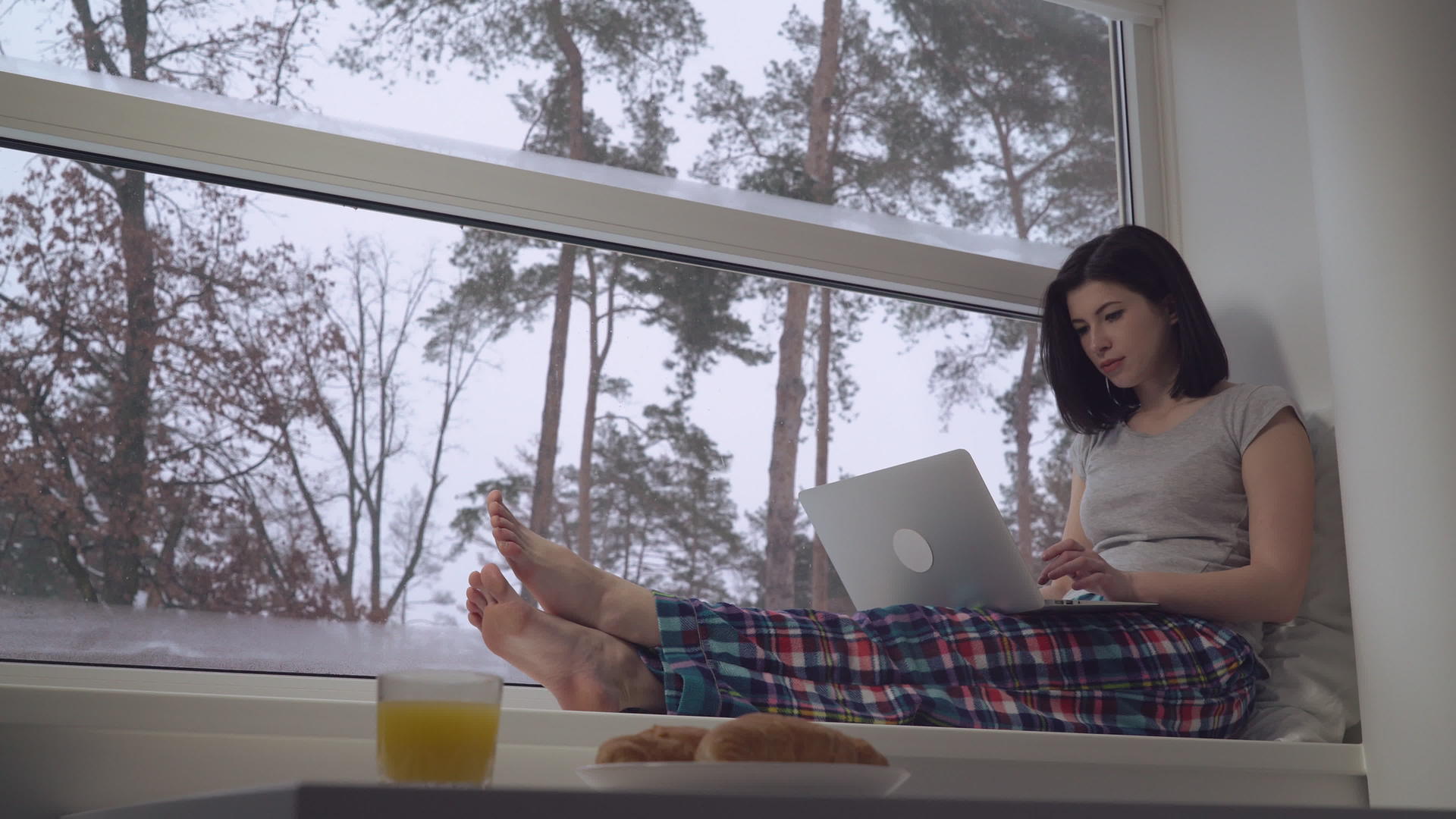 女孩在窗台上用电脑工作视频的预览图