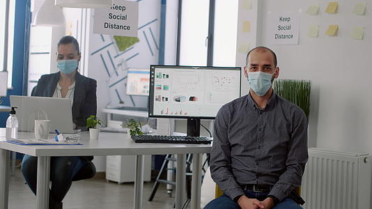 商人在新成立的公司办公室时佩戴保护面具的商家肖像照片视频的预览图