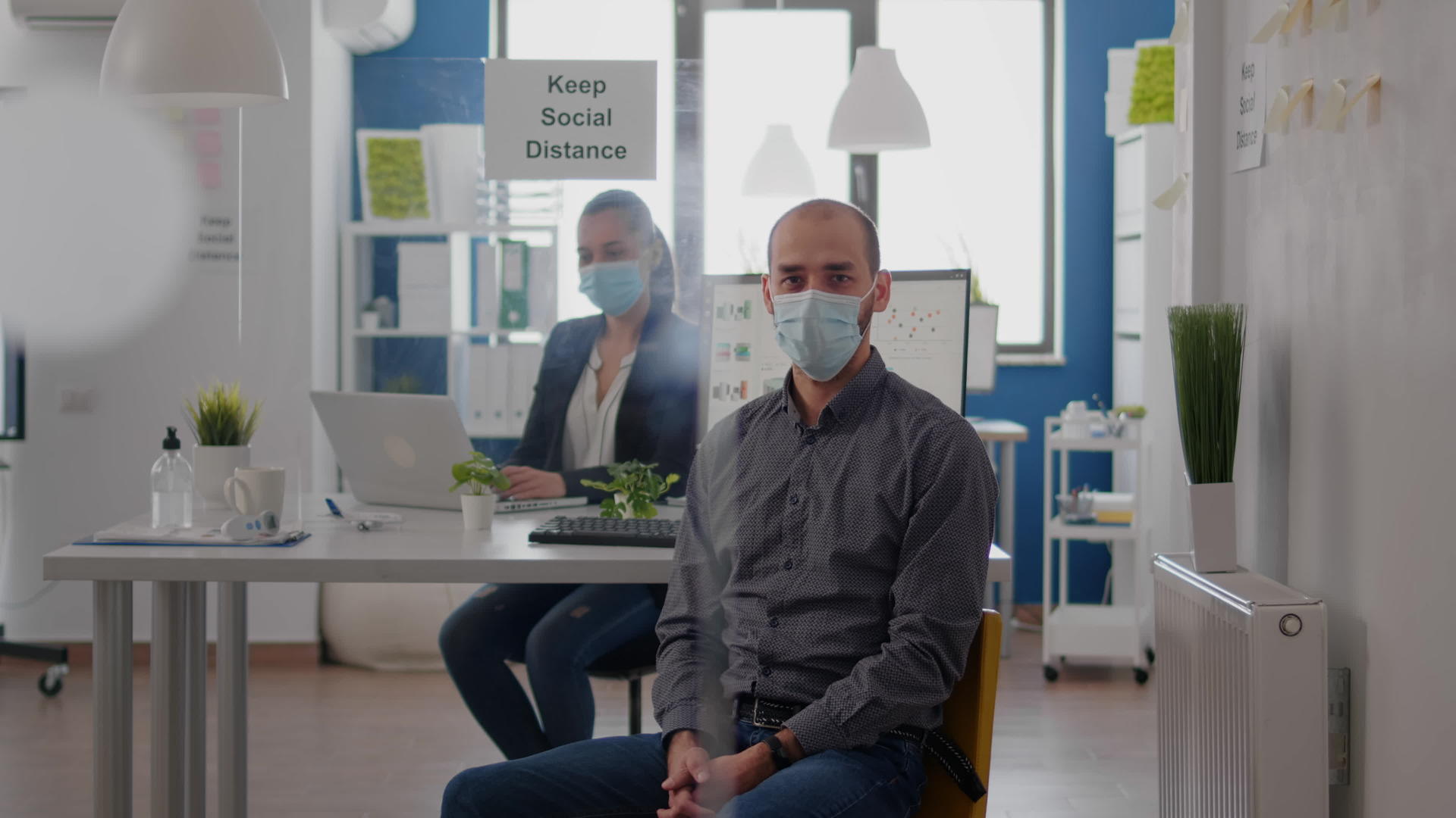 坐在办公桌上的商人戴着医疗面具的肖像照片视频的预览图