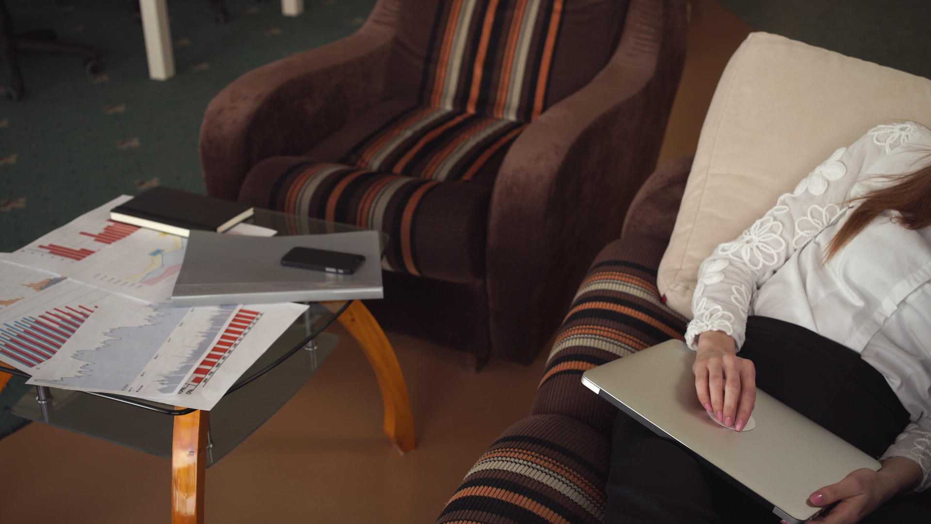 红发女商人用笔记本电脑躺在沙发上视频的预览图